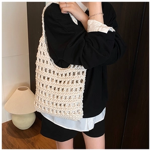 Close-up of beige crochet knit tote bag showing intricate hollow grid pattern details