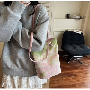 Close-up of floral jacquard tote bag with adjustable shoulder strap on casual outfit