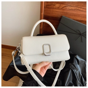 Close-up of a white textured leather crossbody bag with a sleek silver metallic buckle