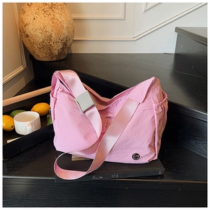 Pink nylon crossbody bag detail with adjustable wide strap and adjustable side drawstring
