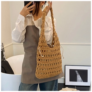 Detail of khaki crochet knit tote bag showing the hollow-out mesh texture and inner lining