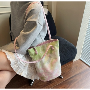 Detail of floral jacquard canvas bucket bag with pink straps and logo patch