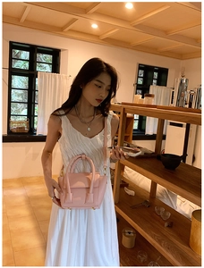 Pink PU leather crossbody bag detail with twin handles and bottom protective metal feet