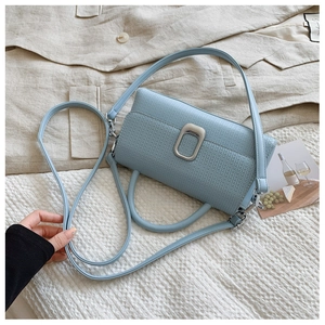 Detail of light blue PU leather handbag with lychee texture and silver metal buckle