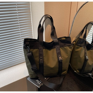 Detail of army green nylon tote bag with functional buckle and adjustable shoulder strap