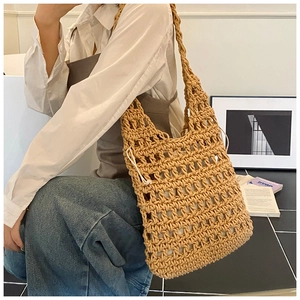 Detail of khaki hollow knit tote bag with inner drawstring pouch on shoulder