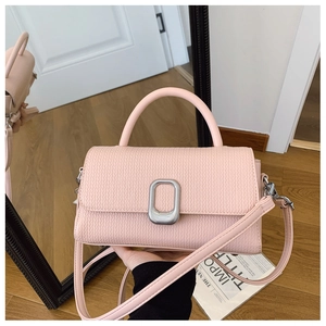 Close-up of pink woven texture handbag with silver oval metal lock and top handle