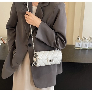 Close-up of a white quilted cylindrical bag with silver twist lock and chain strap