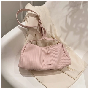 Detail view of pink pleated shoulder bag with vertical texture and adjustable strap