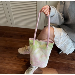 Detail of pink and green floral canvas bucket bag with adjustable shoulder strap