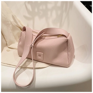 Close-up of pink pleated pillow bag showing vertical texture and gold zipper detail