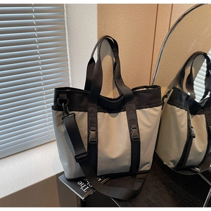 Detailed view of a stylish large capacity tote bag with buckle and contrast ribbon straps