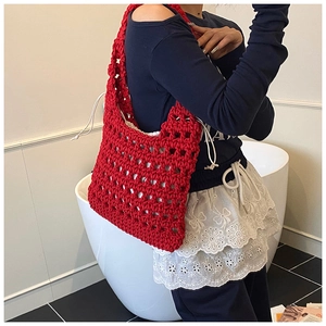 Detail of red hollow knit tote bag showing thick cotton weave and white canvas drawstring liner