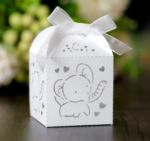 Close-up of laser-cut elephant and heart patterns on the white paper wedding gift box