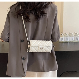 Lifestyle shot showing a white quilted crossbody bag with silver chain and turn-lock closure