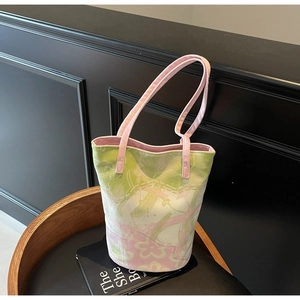 Detail of pink and green floral canvas bucket bag on a vintage wooden stool