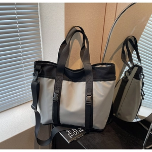Detailed shot of two-tone large tote bag with buckle straps and adjustable strap
