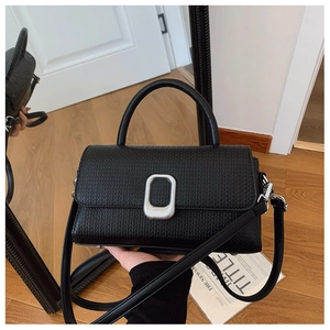 Detail of black embossed leather handbag with silver metallic twist lock closure