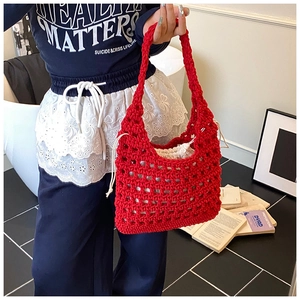 Detail of red hollow knit tote bag featuring a white drawstring liner with wavy lace trim