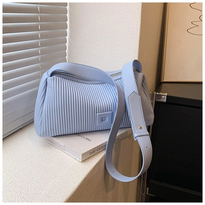 Detail view of light blue pleated texture on shoulder bag with adjustable leather strap