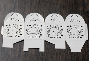 Detail of laser-cut elephant and heart pattern on flat white wedding candy gift box