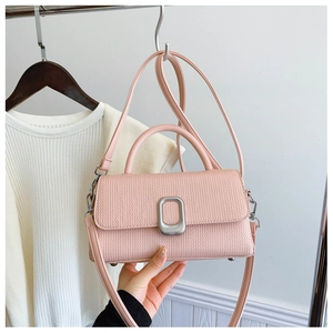 Detailed close-up of pink faux leather handbag featuring premium woven texture and silver buckle