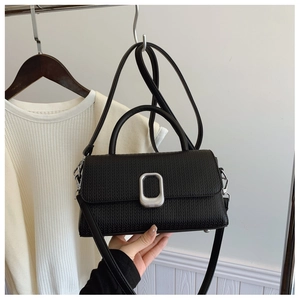 Close-up of black woven texture leather bag with silver buckle and top handle