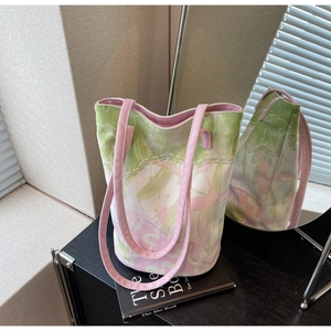 Detailed view of pink and green jacquard floral fabric and shoulder strap on a bucket bag