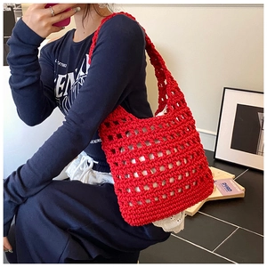 Macro detail of red hollow knit tote bag featuring large mesh pattern and lace lining