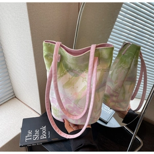 Close-up of floral jacquard tote bag with pink straps and brand label on fabric