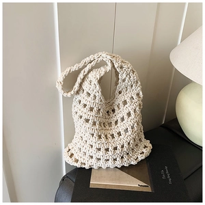 Detail of hand-woven hollow knit tote bag in cream white featuring rhombus patterns