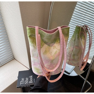 Close-up of floral canvas tote bag with pink-green gradient and logo patch detail