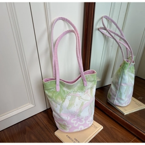 Detail of floral canvas bucket bag showing abstract pink flower patterns and pink strap