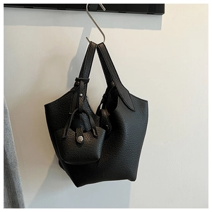 Detail of black lychee grain leather bucket bag with mini charm on metal hook