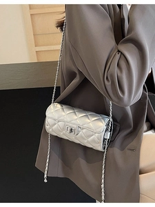 Silver quilted chain shoulder bag with cylindrical design and metallic finish on a model