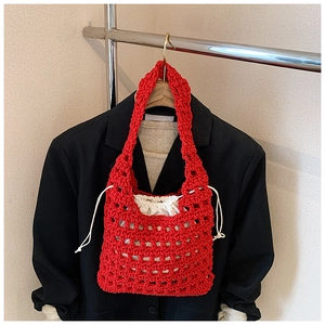 Detail of red hollow knit tote bag featuring a white drawstring inner pouch for women