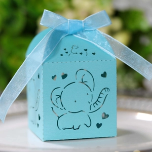 Macro shot of silver elephant laser-cut candy box with light blue ribbon and heart patterns