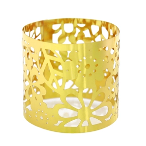Macro shot of gold laser-cut hollow pattern on metallic candle wrap holder ornament