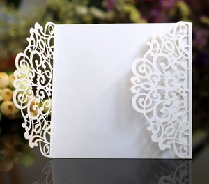Macro view of laser-cut white wedding invitation with elegant lace patterns