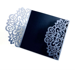 Macro detail of laser-cut floral pattern on deep blue and glittery wedding card cover