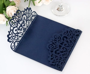Detail of laser-cut navy blue wedding invitation cover with pearlescent floral hollow patterns