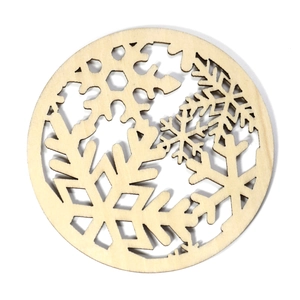 Macro detail of laser-cut snowflake patterns on a round wooden Christmas coaster