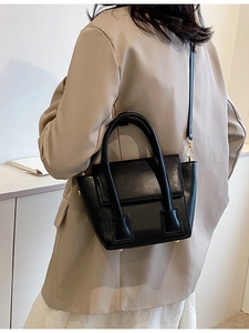 Chic black trapezoid PU leather handbag with dual top handles and long shoulder strap