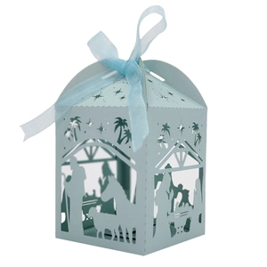 Macro shot of light blue Christmas candy box with hollow nativity scene and ribbon