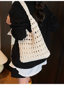 Hollow knit tote bag in creamy white color shown with model for a casual look