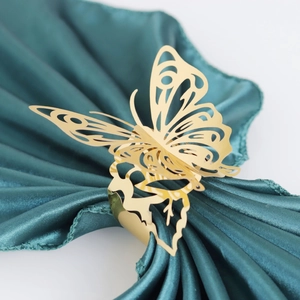 Detailed view of a gold 3D butterfly napkin ring with hollow wings on dark satin cloth