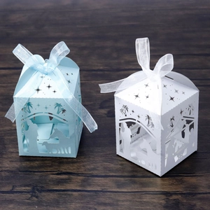 Detail of laser-cut Nativity scene candy boxes with star patterns and organza ribbons