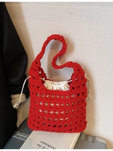 Handcrafted red knit mesh tote bag with white drawstring liner on a dark backdrop