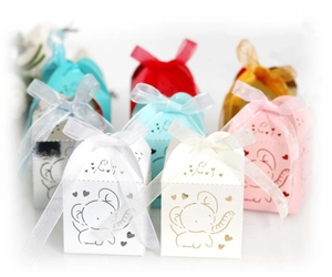 Close-up of laser-cut elephant candy boxes with sheer organza ribbons in various colors