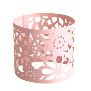 Detailed macro view of laser-cut pink pearlescent cupcake wrapper with floral pattern